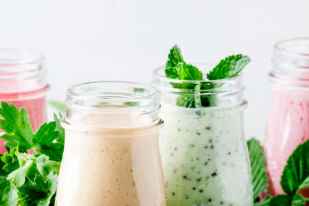 Healthy and useful colorful berry smoothies with yogurt, fresh fruit and berries on a gray background, selective focusの写真素材