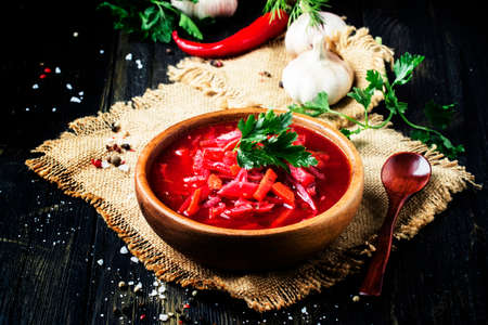 Borsch soup with beets, cabbage and meat in a wooden bowl, rustic style, selective focusの写真素材