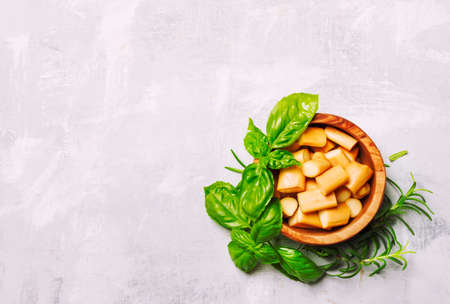 Traditional smoked chechil cheese in bowl with spicy herbs, top viewの写真素材