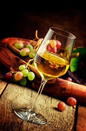 Autumn ice wine, ripe grapes and dried leaves, vintage wooden background, selective focusの写真素材