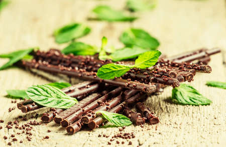 Chocolate branches on old wooden table, selective focusの写真素材