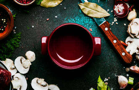 Fresh organic vegetables, ingredients, spices and meat for soup or broth on vintage kitchen table background with rred cocking pan. Top view, place for text. Healthy cooking and eating conceptの写真素材