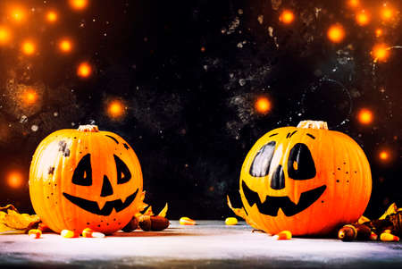 Halloween composition with pumpkins lanterns, with lights and fallen leaves on a dark blue background, selective focusの写真素材