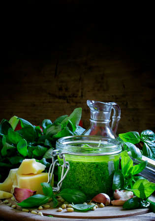 Pesto sauce in a glass jar, vintage wooden background, selective focusの写真素材