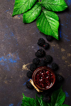 Blackberry jam in glass jar on brown background, top viewの写真素材