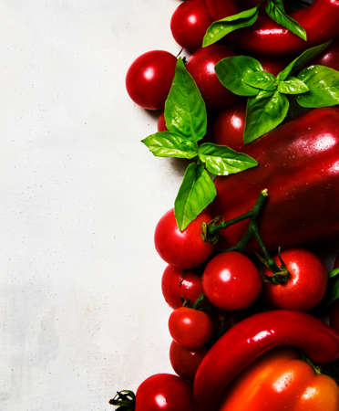 Red peppers, tomotoes and basil, food background, top viewの写真素材