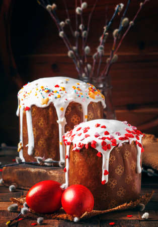 Happy easter! Traditional Russian easter cake Kulich with colored red eggs, decorated with hearts,...