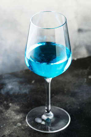 Exotic blue wine, trendy non-classical drink in wine glass on gray backgroundの写真素材