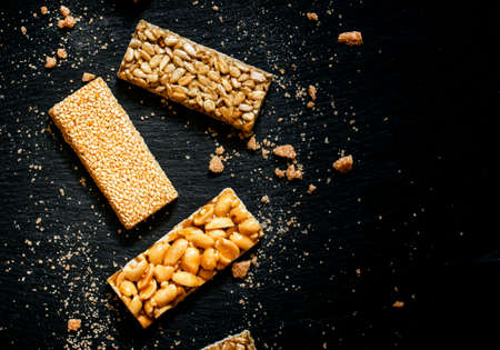 Sesame seeds, sunflower and peanuts in caramel, dark food background, selective focusの写真素材