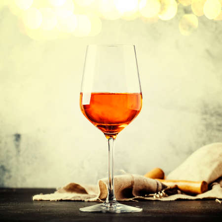 Trendy food and drink, orange wine in glass, gray table background, space for text, selective focus. Square image, vintage toningの写真素材