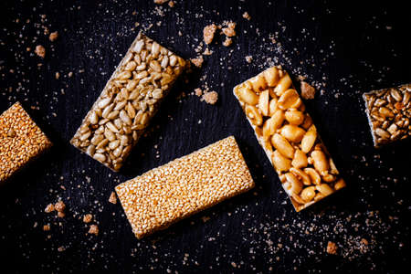 Sesame seeds, sunflower and peanuts in caramel, dark food background, selective focusの写真素材