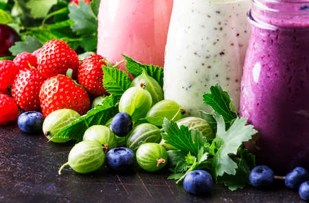 Berry fruit cokctalis, smoothies and milkshakes, fresh fruit and berries on brown table, still life, selective focusの写真素材