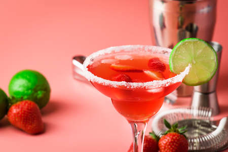 Strawberry red margarita alcoholic cocktail with tequila, liqueur, berries, lime juice, sugar and ice, pink background, copy spaceの写真素材
