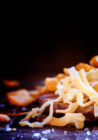 Dried squid, salted beer snacks. Junk food concept. Dark wood background. Low key, selective focus.の写真素材