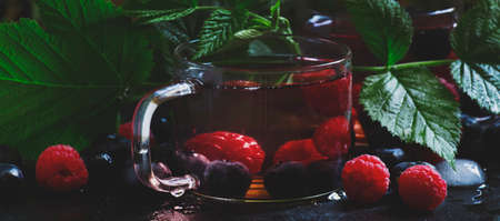 Ice herbal tea with forest berries, black table, selective focusの写真素材
