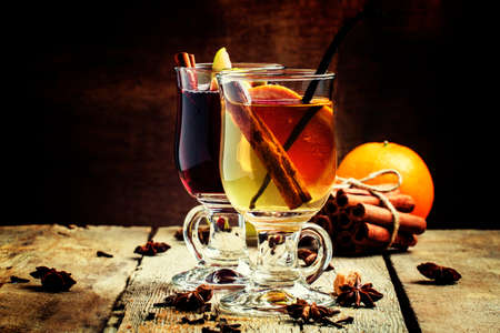 Hot mulled wine from red and dry white wine with fruit and spices ,, vintage wood background, selective focusの写真素材