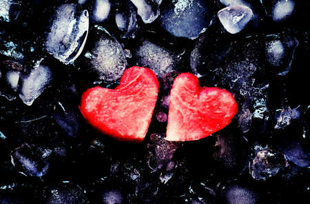 Red sweet watermelon hearts on crushed ice, dark food background, top view