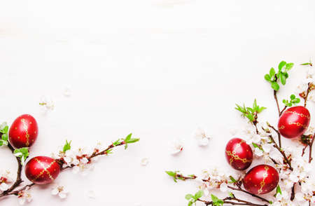 Easter eggs and spring white flowers on Easter white background with copy spaceの写真素材