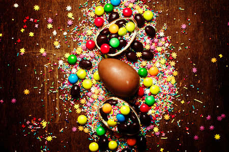 Easter background with chocolate eggs and multi-colored sugar, top viewの写真素材