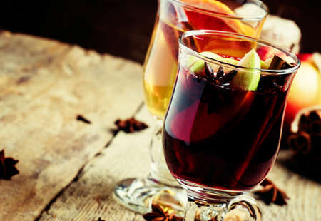 Hot mulled wine from red and dry white wine with fruit and spices ,, vintage wood background, selective focusの写真素材