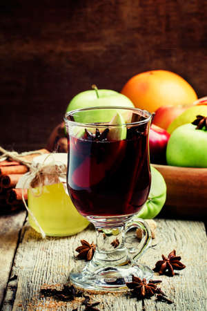 Hot mulled wine with apple and cinnamon, vintage wooden background, rustic style, selective focusの写真素材