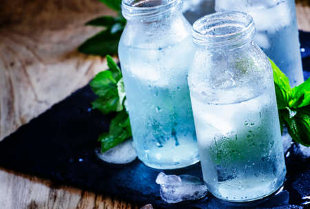 Cold isotonic solution for sports nutrition in glass bottles, dark background, selective focusの写真素材