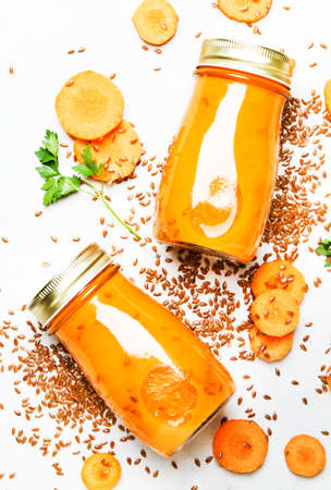 Carrot juice or smoothies with flax seeds in glass bottles, vegan beverage, healthy drink for clean...