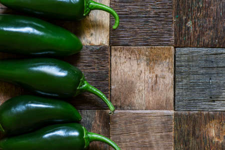 Food background, jalapeno on vintage wooden table, top view, low keyの写真素材