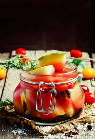 Marinated or pickled watermelon in a glass jar, vintage wooden background, selective focusの写真素材