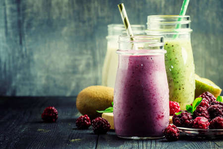 Berry smoothies in bottles, gray background, selective focusの写真素材