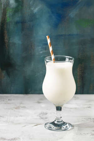 Milkshake or milk cocktail with ice cream and natural vanilla, blue background, copy space,...