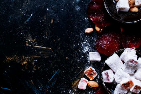 Eastern sweets with sugar powder, pistachios and rose petals, food background, top viewの写真素材