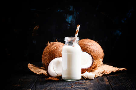 Coconut milk in a glass bottle, dark background, selective focusの写真素材