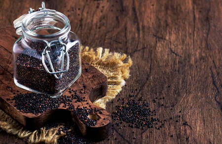 Black quinoa seeds in bowl on rustic wooden tableの写真素材