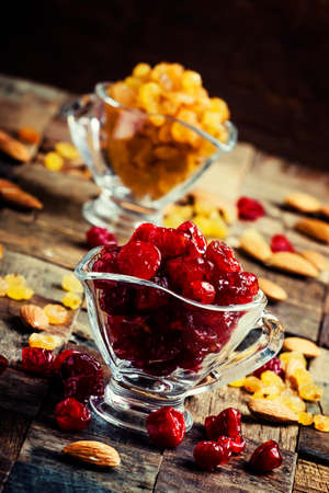 Dried cherries in a glass bowl, vintage wooden background, selective focusの写真素材