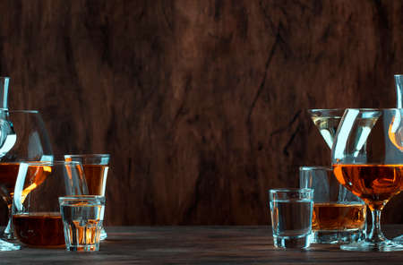 Strong Spirits Set. Hard alcoholic drinks in glasses in assortment: vodka, cognac, tequila, brandy and whiskey, grappa, liqueur, vermouth, tincture, rum. Vintage bar counter background, selective focusの写真素材