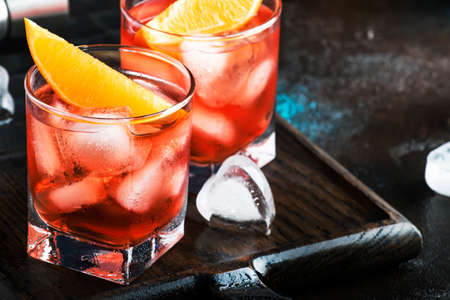 Negroni alcoholic cocktail with dry gin, red vermouth and red bitter, orange slice and ice cubes....