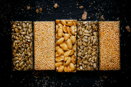 Sesame seeds, sunflower and peanuts in caramel, dark food background, selective focusの写真素材