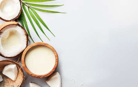 Coconut non dairy vegan milk in wooden bowl. Gray backgound top view with copy space, hard lightの写真素材