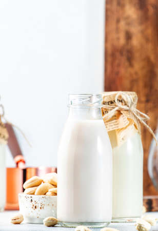 Vegan Cashew nut milk in bottles, closeup, white table background. Non dairy alternative milk. Healthy vegetarian food and drink concept. Copy spaceの写真素材