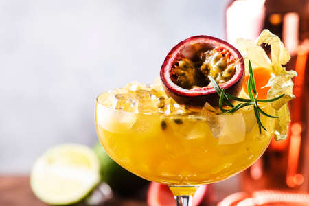 Passion fruit Alcoholic cocktail with gin, juice, rosemary and ice. Gray background, copper bar tools, copy spaceの写真素材