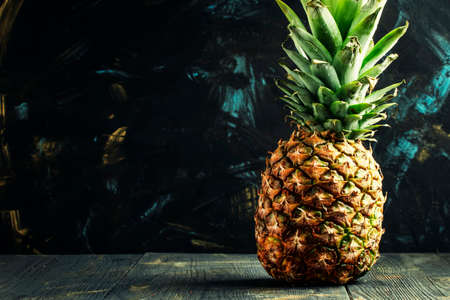 Fresh pineapple, dark wood background, selective focus