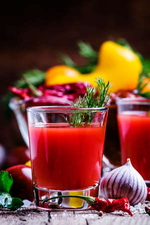 Spicy tomato juice with salt and spices, vintage wooden background, rustic style, selective focusの写真素材