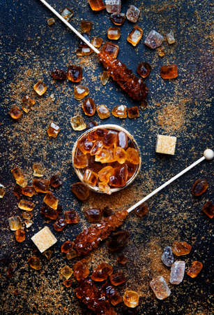 Sweet food background, assorted white and brown sugar on a dark background, top viewの写真素材