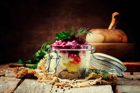 Traditional Russian salad herring under a fur coat, vintage wood background, selective focusの写真素材