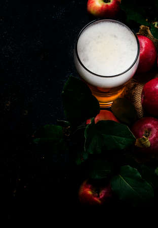 Apple cider in beer glass with fresh apples, black background, top viewの写真素材