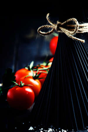 Spaghetti and tomatoes, still life in low key, selective focusの写真素材