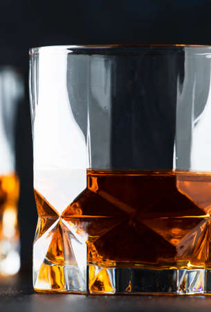 Bourbon in glass, american corn whiskey, dark bar counter, selective focusの写真素材