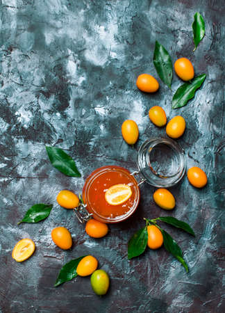 Kumquat confituku in glass jar, silver stone background, top viewの写真素材