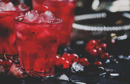 Rosso berry crash, alcoholic cocktail with red currant, vermouth and ice, black background, selective focus and toned imageの写真素材